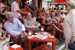 French politician and wife of France's former president, Bernadette Chirac (R) speaks to her husband Jacques Chirac  (2ndL) while he sits at a table outside the famous Le Senequier café in the French Riviera searesort of Saint-Tropez on August 14, 2011. AFP PHOTO SEBASTIEN NOGIER
